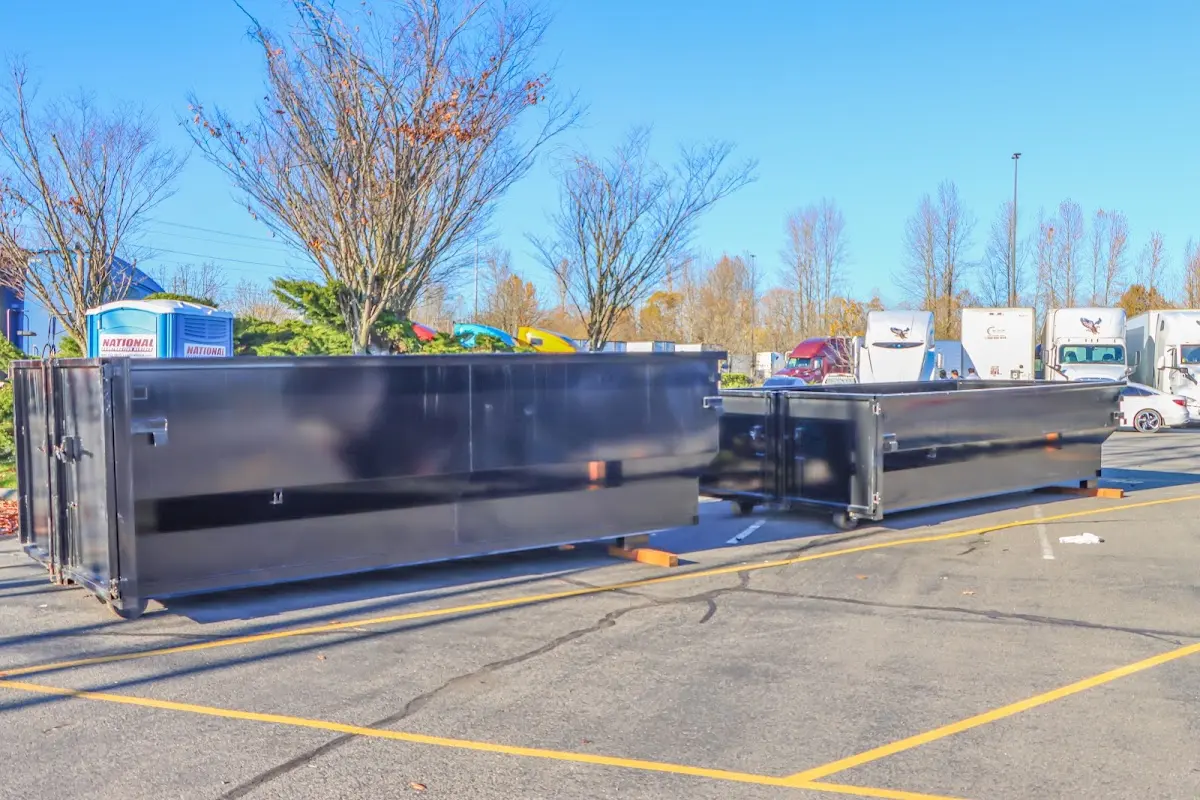 Professional dumpster rental service with roll-off container on residential driveway in Poteau